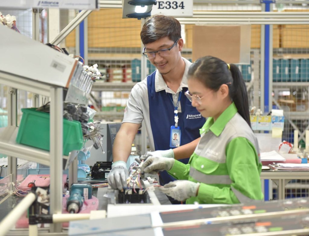 one-team two employees working together on machine part wiring